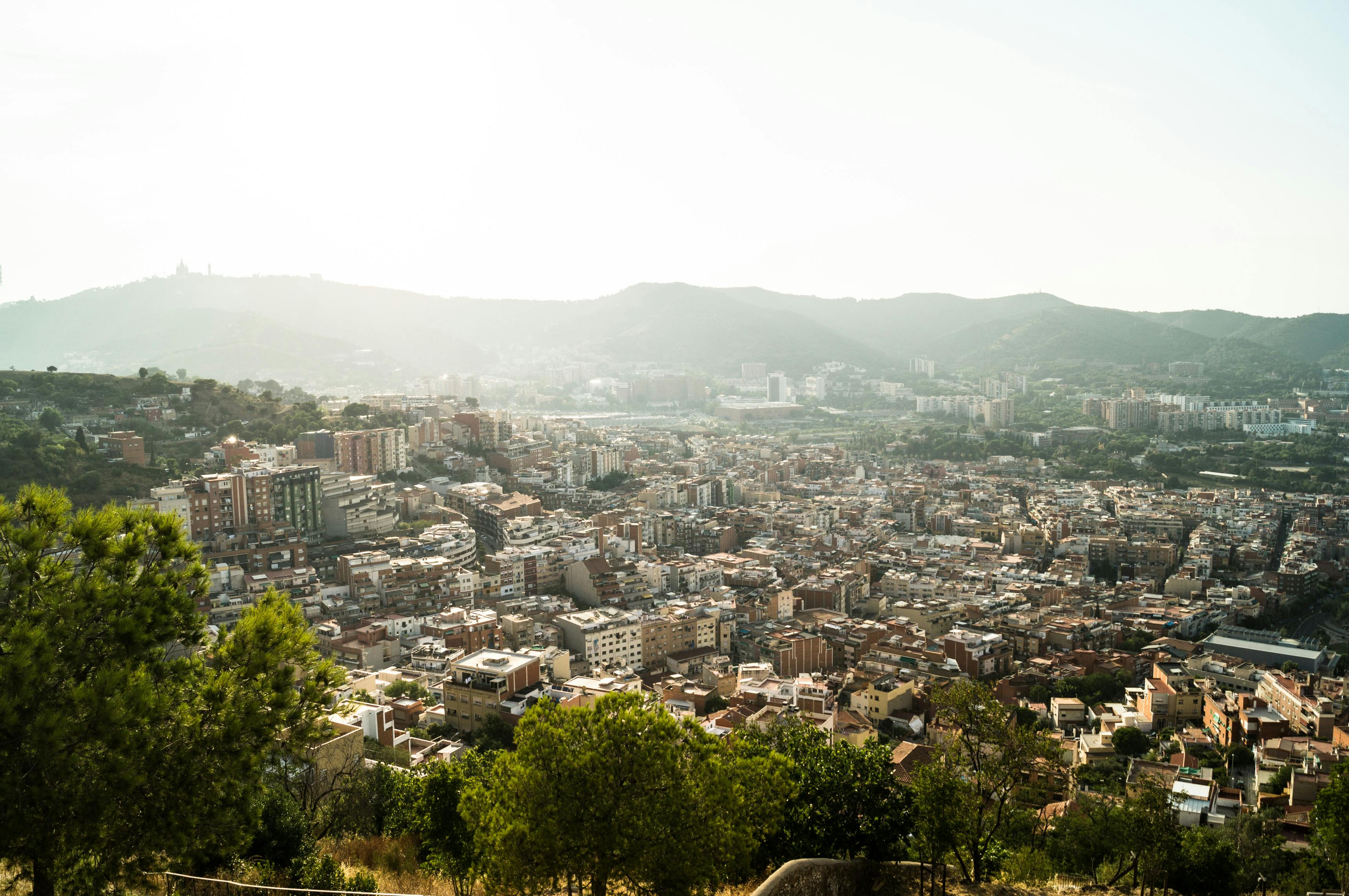 Wide Barcelona city view framed by the hills.